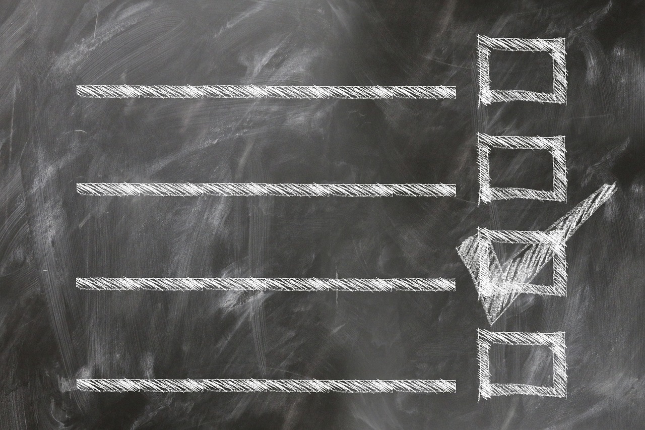 A chalkboard checklist with horizontal lines and a single box marked with a check.